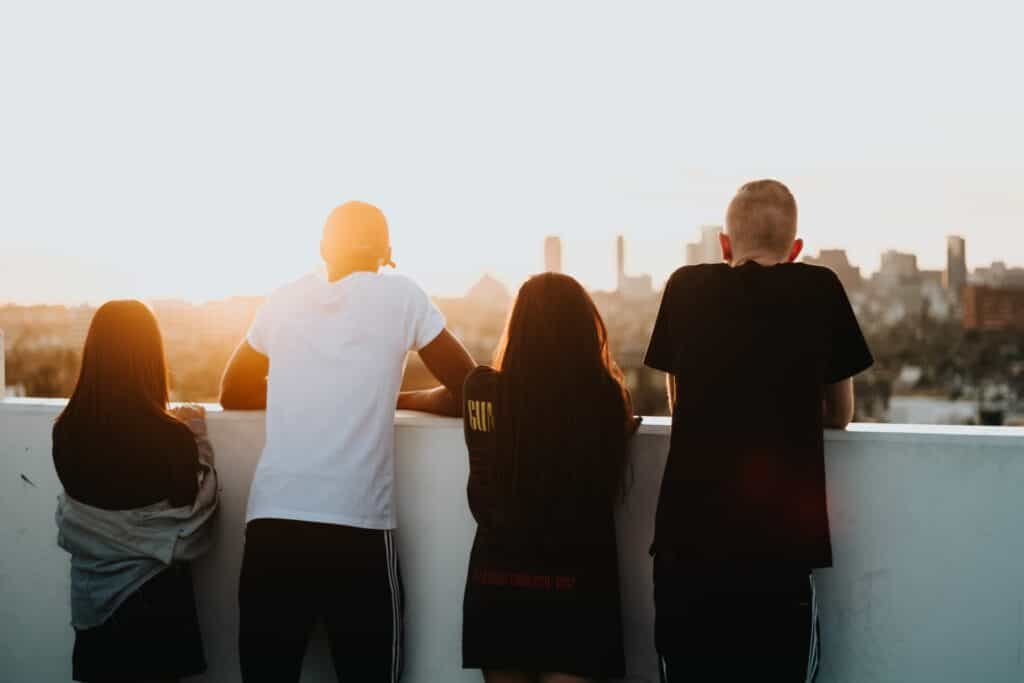 Group of teens on a rooftop, looking out over the city
